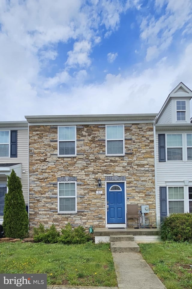 townhome / multi-family property featuring stone siding