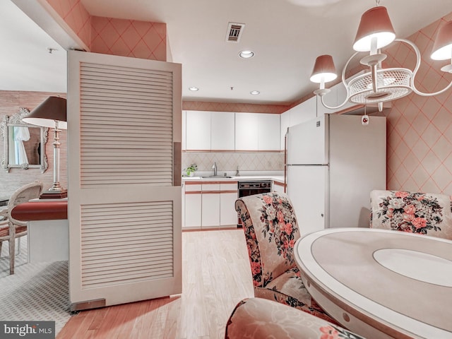 1 Gristmill Ct Unit 103, Pikesville, MD 21208 - kitchen with freestanding refrigerator, white cabinets, light wood finished floors, light countertops, and recessed lighting