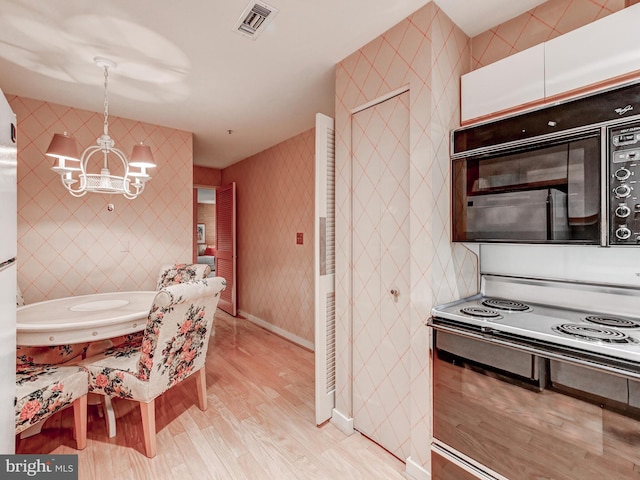 1 Gristmill Ct Unit 103, Pikesville, MD 21208 - kitchen featuring black microwave, electric range, light wood-type flooring, a chandelier, and decorative light fixtures