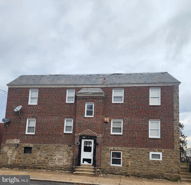 view of front of house with brick siding, stone siding, and entry steps