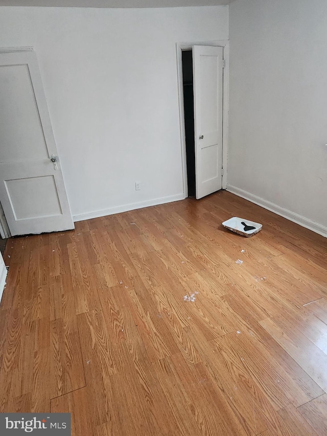 spare room featuring baseboards and light wood-style flooring