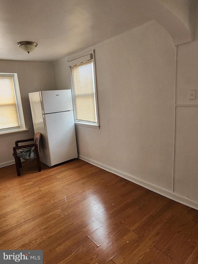 interior space with baseboards, wood finished floors, and a wealth of natural light
