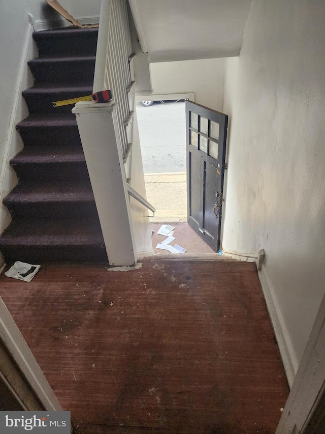 stairway with baseboards and wood finished floors
