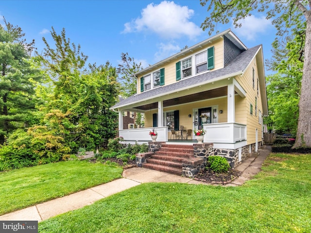 bungalow-style house with a porch, roof with shingles, and a front yard