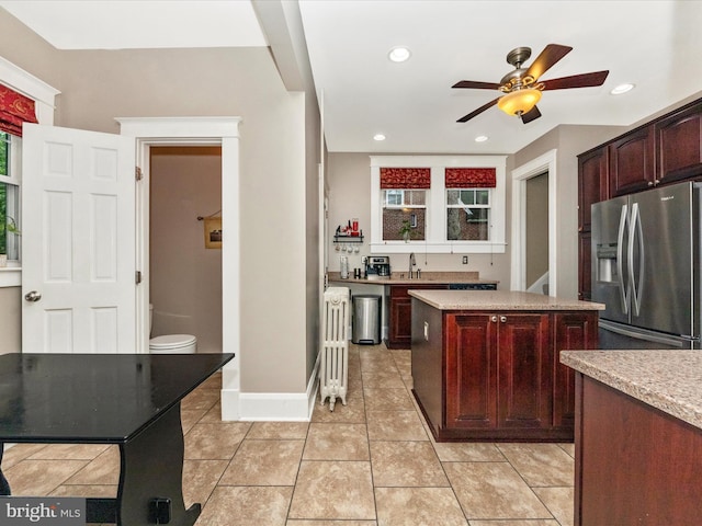 kitchen with a sink, recessed lighting, a kitchen island, a ceiling fan, and stainless steel fridge with ice dispenser