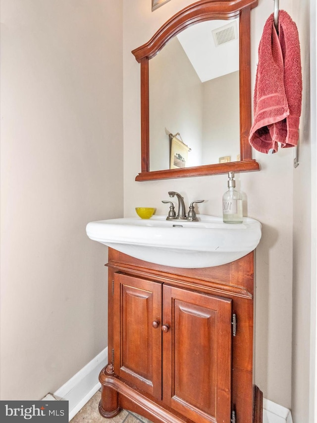 bathroom featuring visible vents, baseboards, and vanity