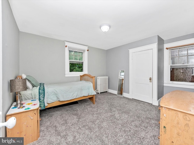 bedroom featuring baseboards, radiator heating unit, and carpet