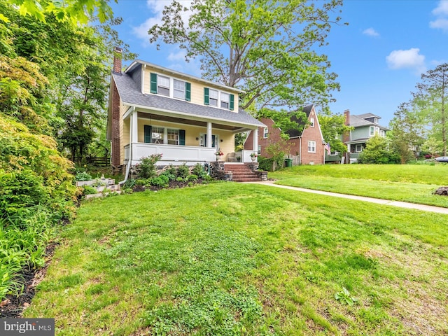 bungalow-style home with a porch, a shingled roof, a chimney, and a front yard
