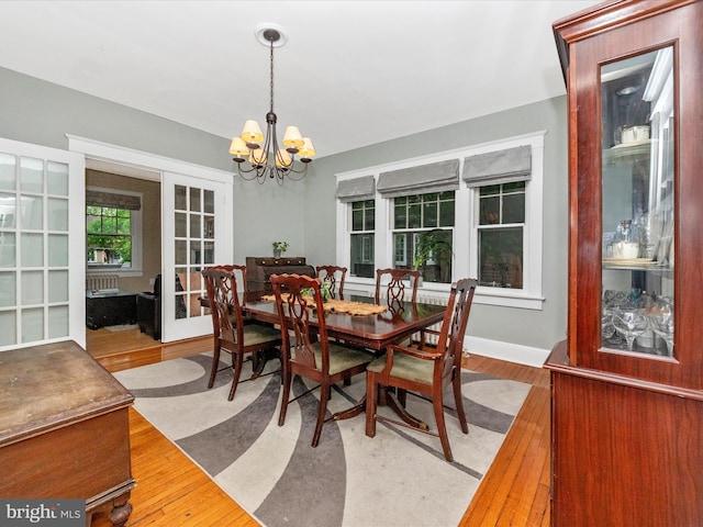 dining space with a notable chandelier and wood finished floors