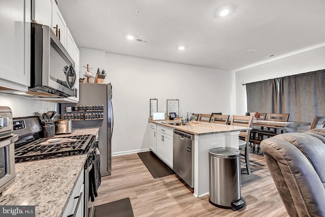 305 Maple Run Dr, York, PA 17404 - kitchen featuring appliances with stainless steel finishes, a peninsula, white cabinetry, light stone counters, and recessed lighting