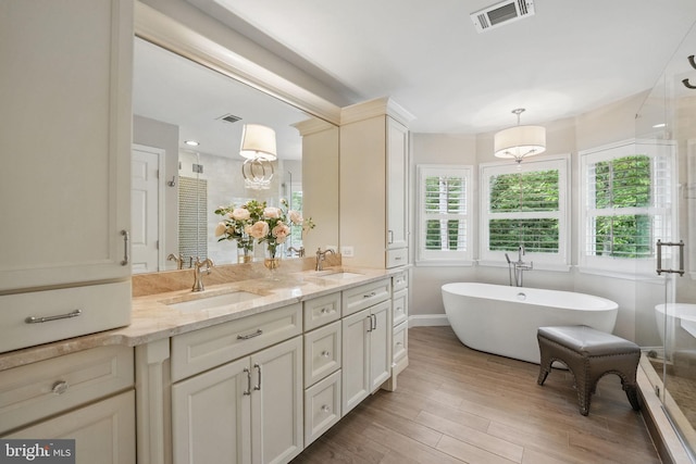 13757 Laurel Rock Dr, Clifton, VA 20124 - bathroom featuring a shower stall, double vanity, a soaking tub, wood finished floors, and baseboards