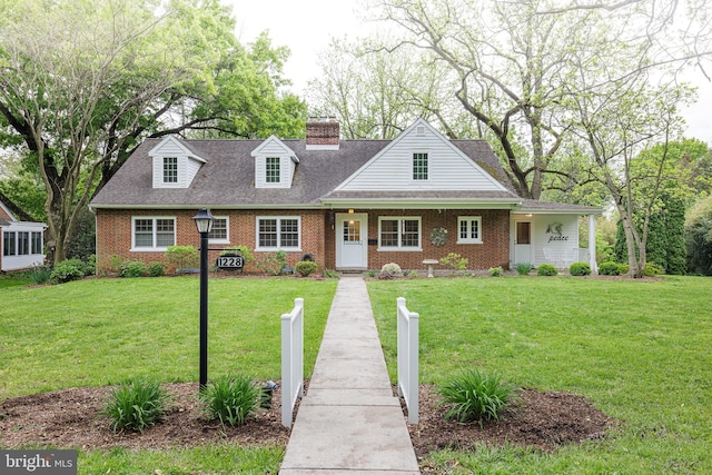 cape cod-style house featuring a front lawn and brick siding