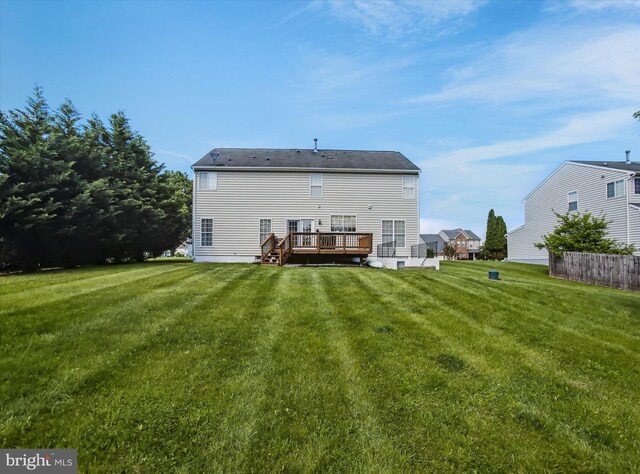 rear view of property with a deck and a yard