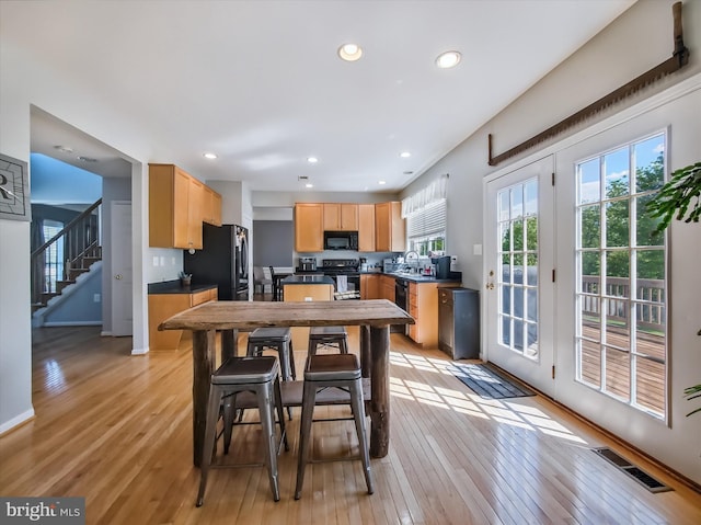 dining area featuring light wood-style floors, recessed lighting, stairway, and baseboards