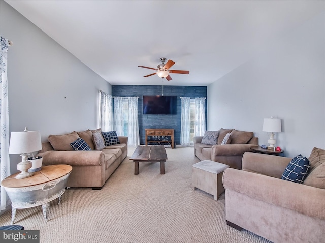 living area with light carpet and ceiling fan