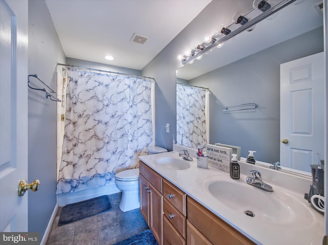 full bath with toilet, double vanity, and baseboards