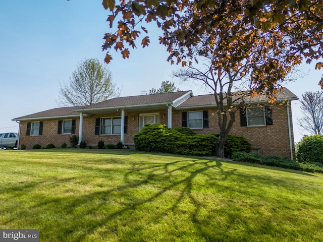 ranch-style house featuring brick siding and a front yard