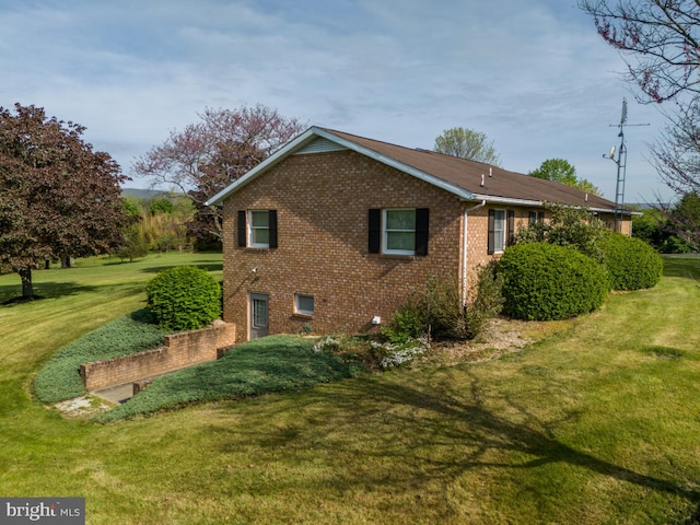 view of property exterior with a yard and brick siding