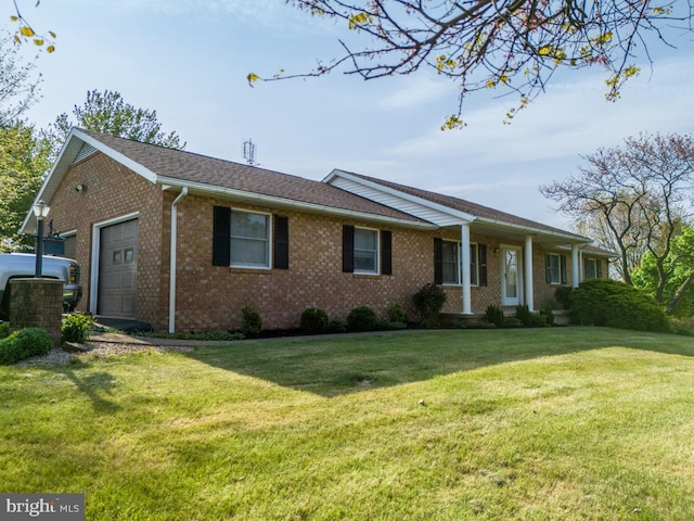 ranch-style home featuring a garage, brick siding, and a front yard