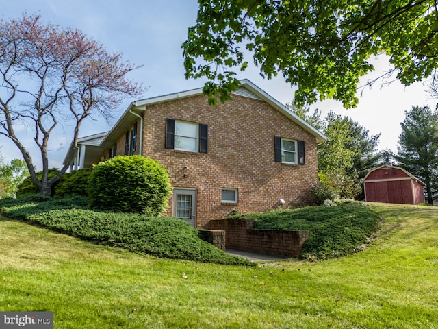 view of property exterior with a yard, an outdoor structure, brick siding, and a garage