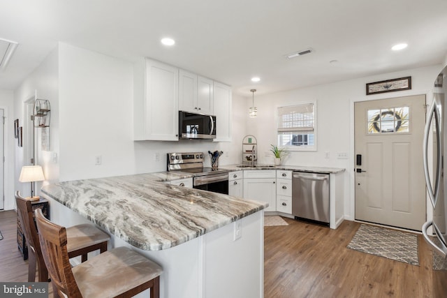 2994 Hope Mill Ln, Adamstown, MD 21710 - kitchen with visible vents, a peninsula, light wood-style floors, a sink, and stainless steel appliances