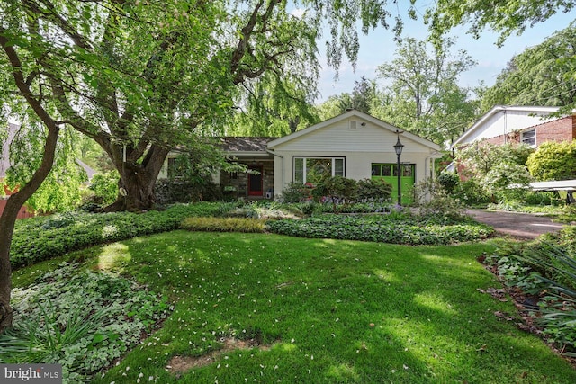 single story home featuring a front lawn