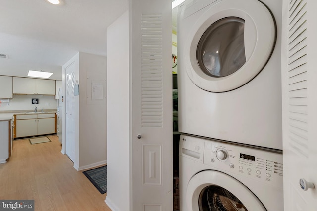 11 142nd St Unit 31003, Ocean City, MD 21842 - laundry room with stacked washer / dryer, light wood finished floors, and baseboards