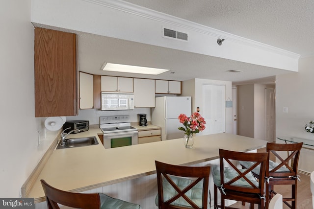 11 142nd St Unit 31003, Ocean City, MD 21842 - kitchen with white appliances, a sink, a peninsula, a textured ceiling, and light countertops