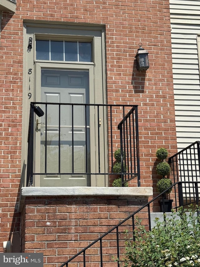 entrance to property featuring brick siding