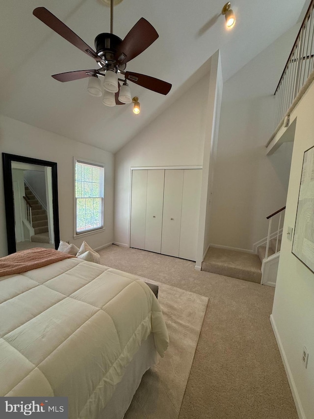 bedroom with baseboards, a closet, high vaulted ceiling, and carpet floors
