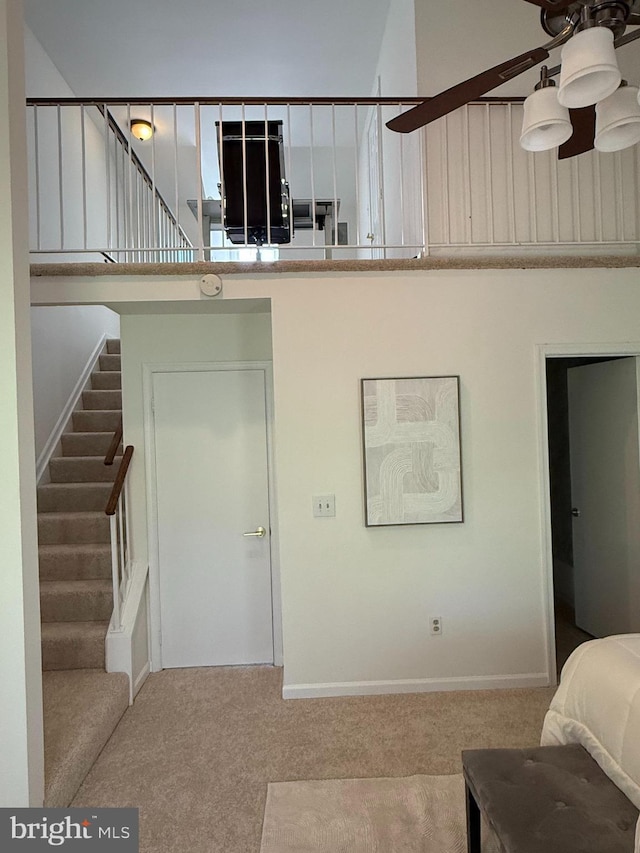 stairway featuring carpet, baseboards, and a ceiling fan