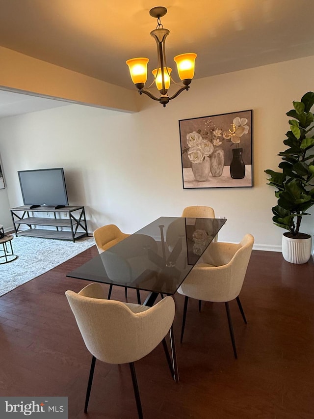 dining area featuring baseboards, a chandelier, and wood finished floors