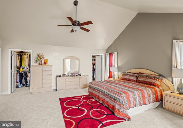 bedroom with a closet, high vaulted ceiling, ceiling fan, a spacious closet, and carpet flooring