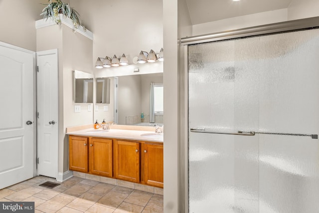 full bathroom featuring a sink, stone finish floor, visible vents, a stall shower, and double vanity