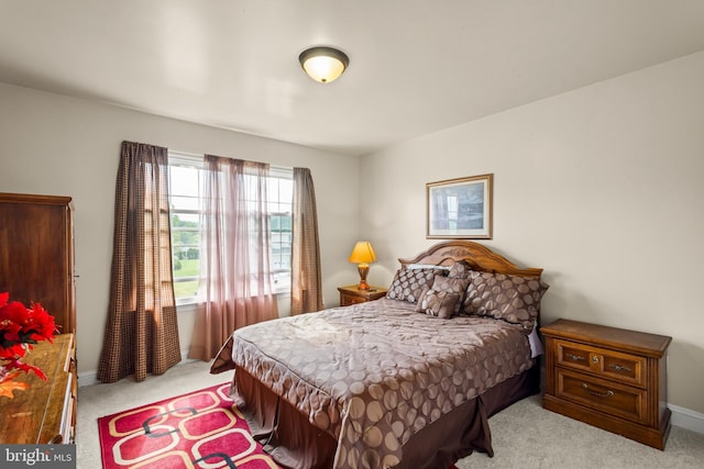 bedroom with baseboards and light colored carpet