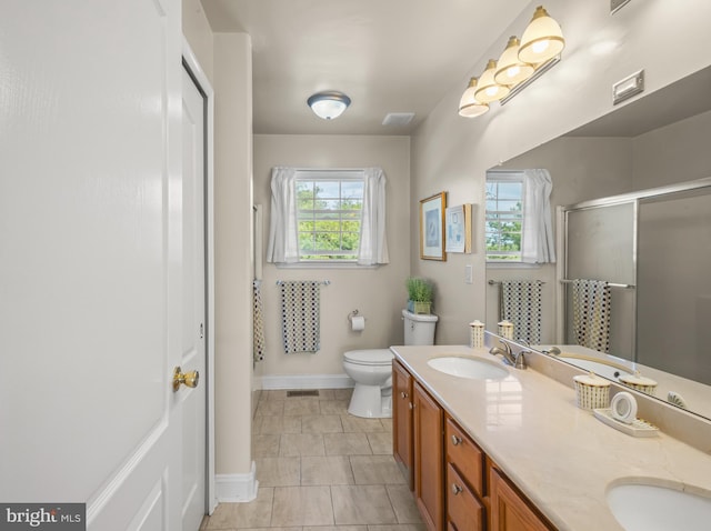 full bathroom with double vanity, toilet, a shower stall, and a sink