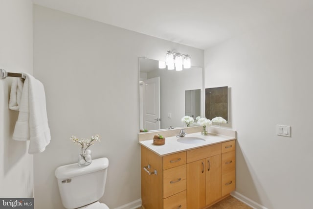 bathroom with vanity, baseboards, and toilet