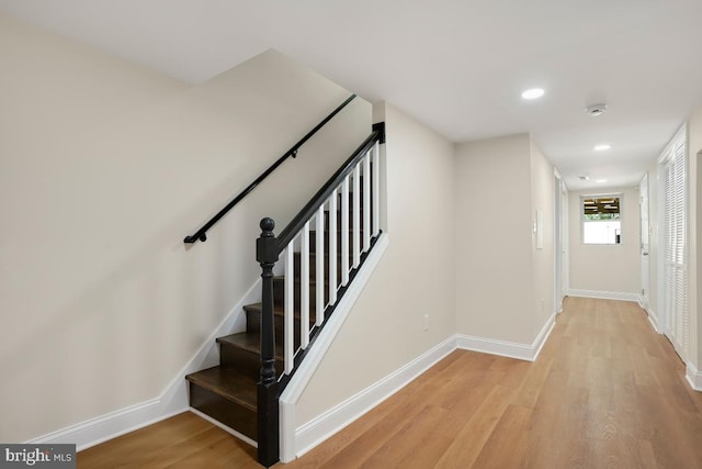 stairway featuring recessed lighting, baseboards, and wood finished floors