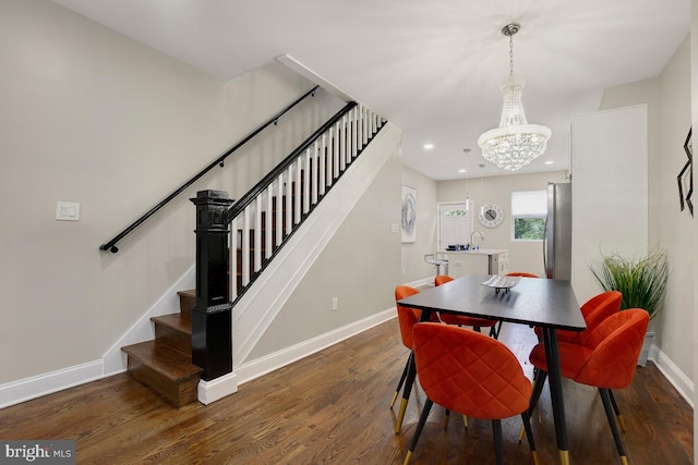 dining room featuring a notable chandelier, recessed lighting, baseboards, wood finished floors, and stairway
