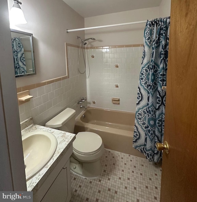 full bath with tile walls, shower / bath combination with curtain, toilet, vanity, and tile patterned flooring