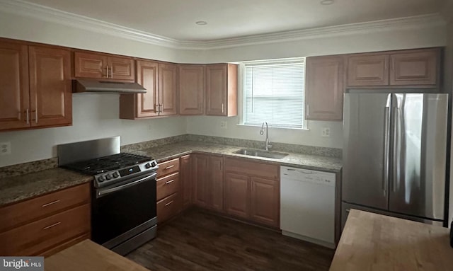 kitchen featuring appliances with stainless steel finishes, a sink, under cabinet range hood, dark wood-type flooring, and crown molding