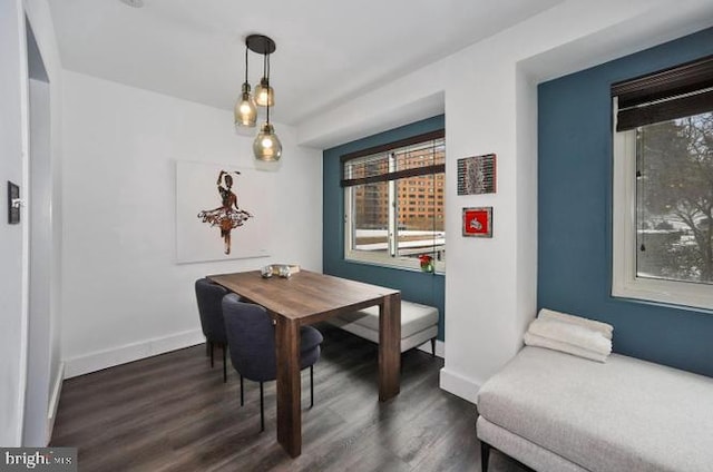 dining space with dark wood-style flooring and baseboards