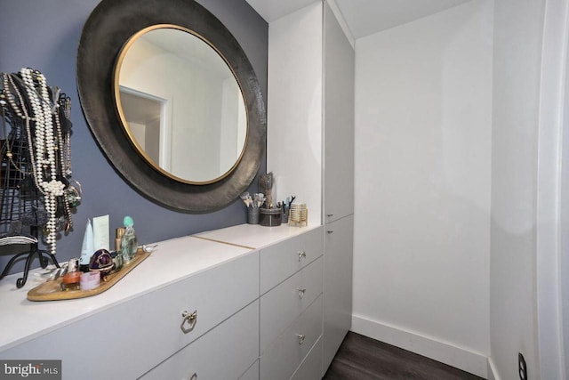 bathroom with baseboards, vanity, and wood finished floors