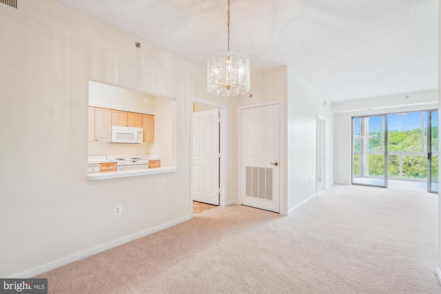 unfurnished dining area with light colored carpet, a chandelier, baseboards, and visible vents