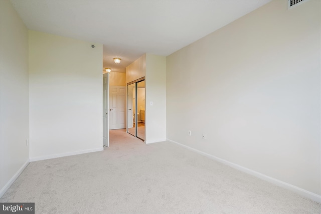 carpeted empty room featuring baseboards and visible vents