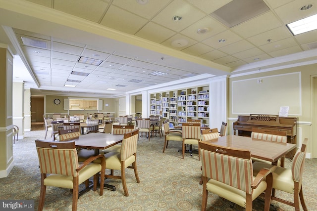 dining area featuring carpet flooring, baseboards, and a drop ceiling