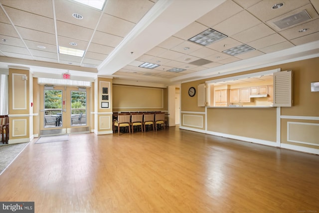 misc room with a decorative wall, a drop ceiling, and wood finished floors