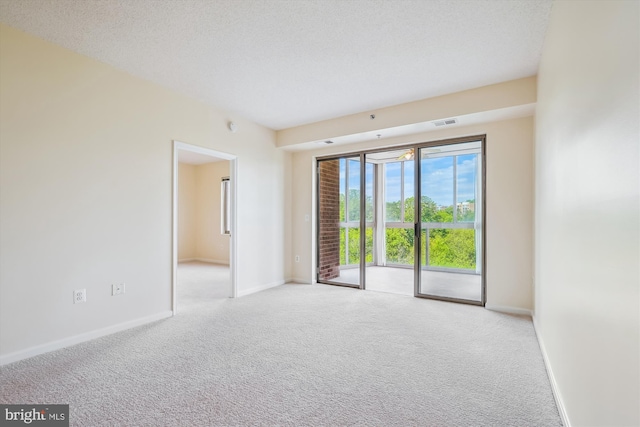 spare room featuring carpet flooring, baseboards, and visible vents
