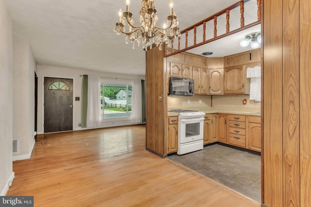 586 Rita Dr, Odenton, MD 21113 - kitchen with black microwave, white gas range, light countertops, a chandelier, and light wood-style floors
