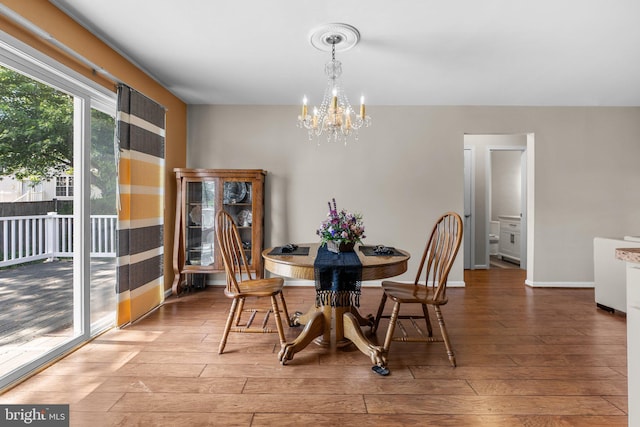 dining room with a chandelier, wood finished floors, and baseboards